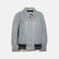 Gray leather jacket with navy accents on a white background