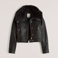 Black leather jacket with fur hood on a light gray background