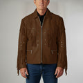 Man wearing a brown leather jacket with fringes and studs on a plain background