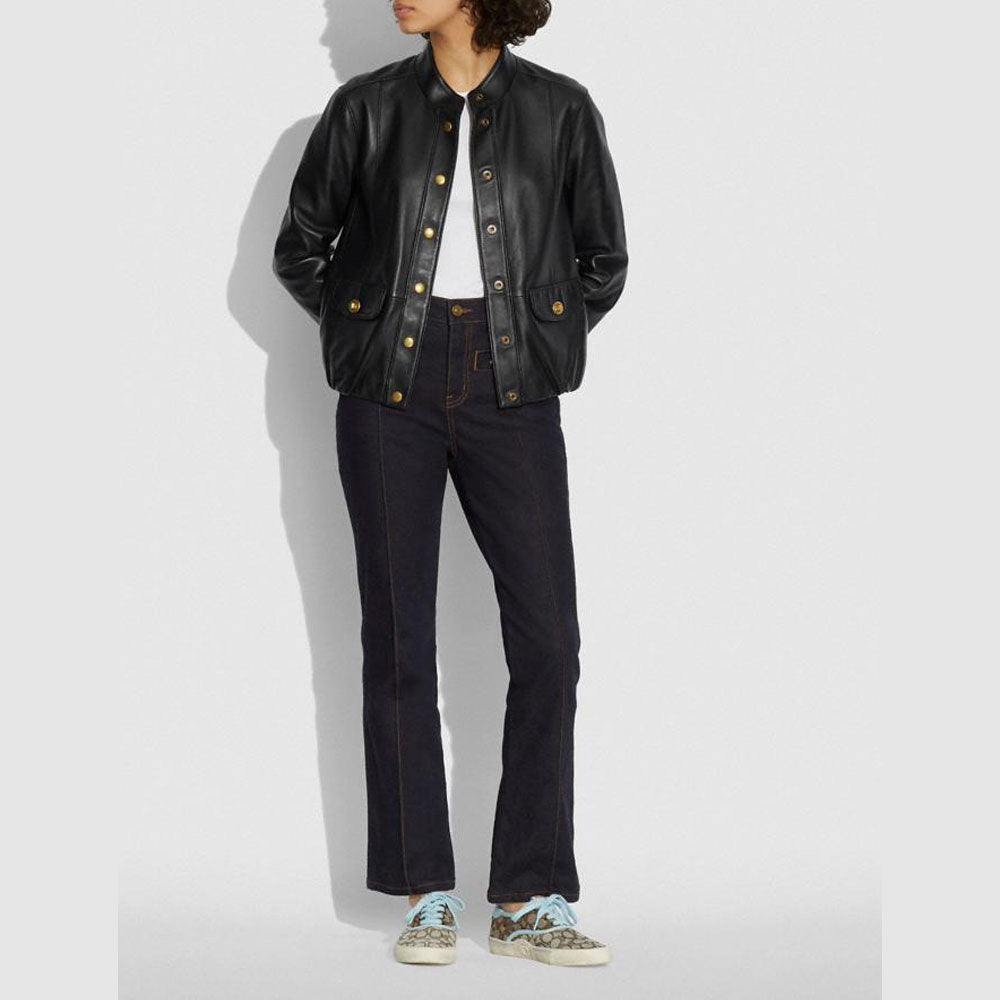Person wearing a black leather jacket and dark jeans on a white background