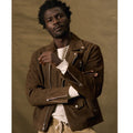 Man wearing a brown jacket over a white shirt against a beige background