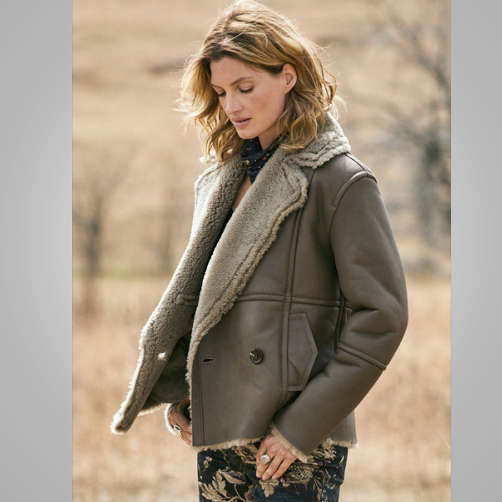 Woman wearing a brown leather coat with fur lining in a natural setting