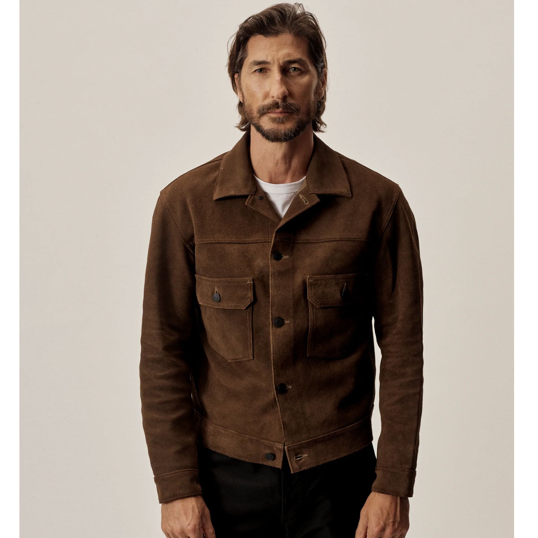 Man wearing a brown jacket against a plain background