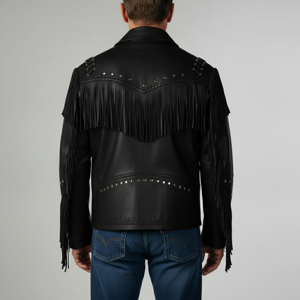 A man viewed from the back wearing a black leather fringe jacket with silver studs, paired with blue jeans, against a light gray studio background.
