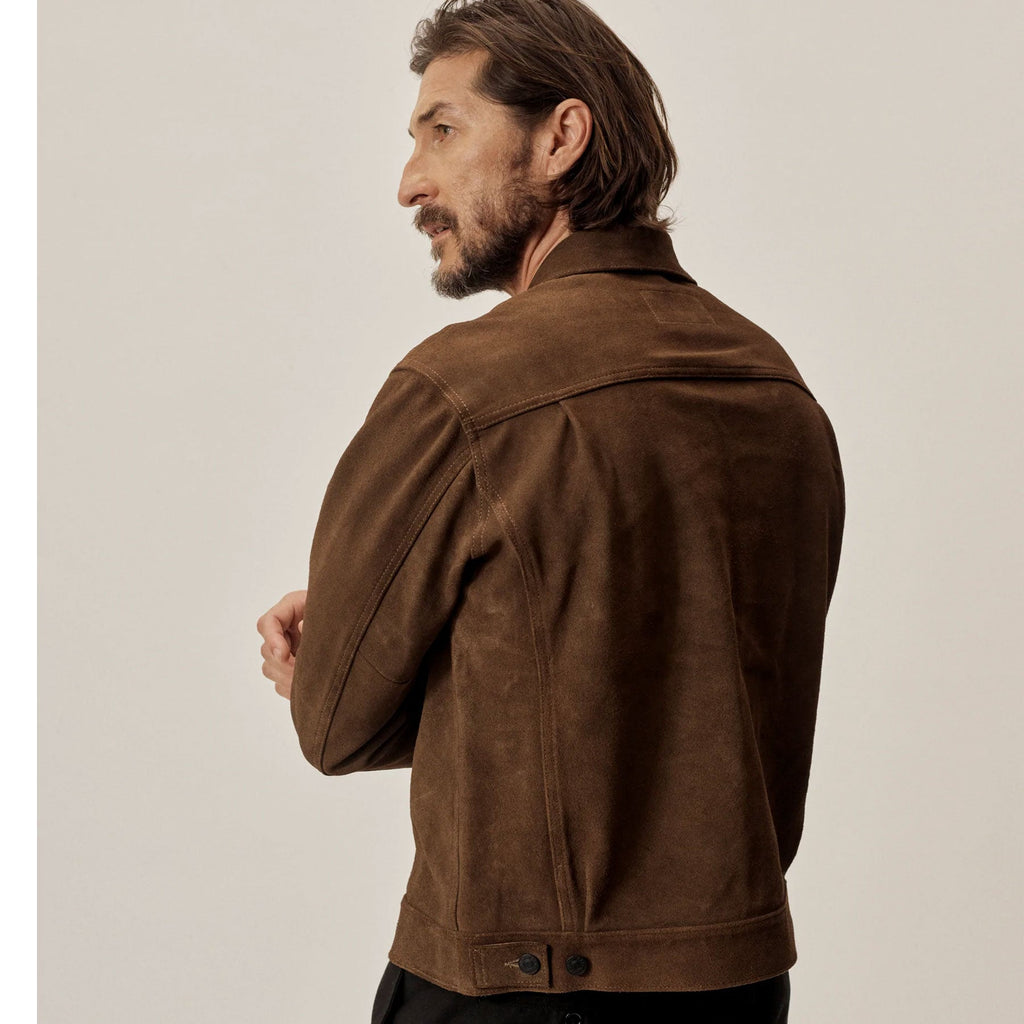 Man wearing a brown leather jacket against a plain background
