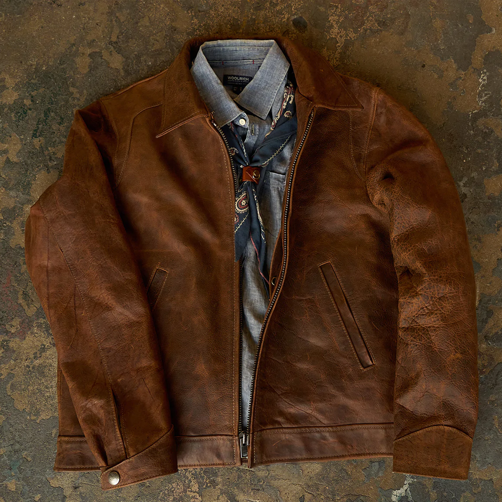 Brown leather jacket with a shirt and scarf on a textured surface