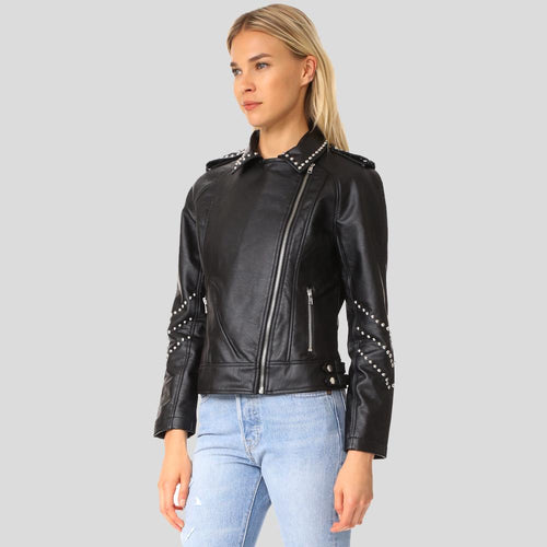 Woman wearing a black leather jacket with studded details on a gray background