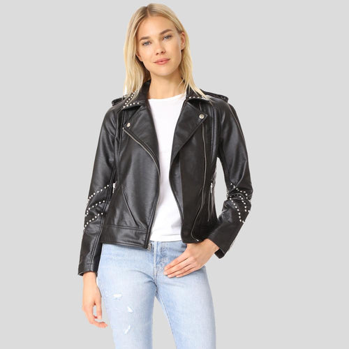 Woman wearing a black leather jacket with studded details on a gray background