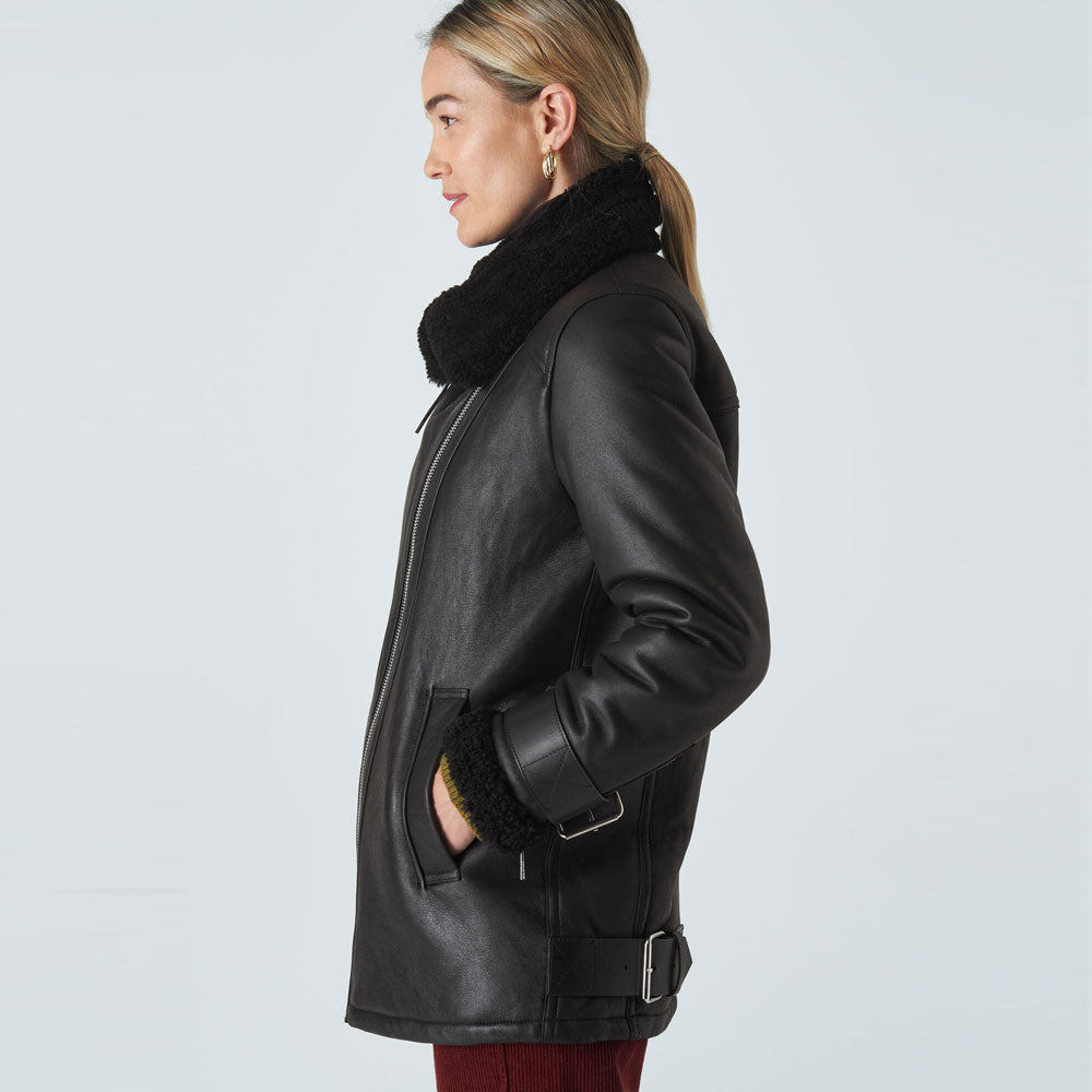 Person wearing a black leather coat with fur collar on a light gray background