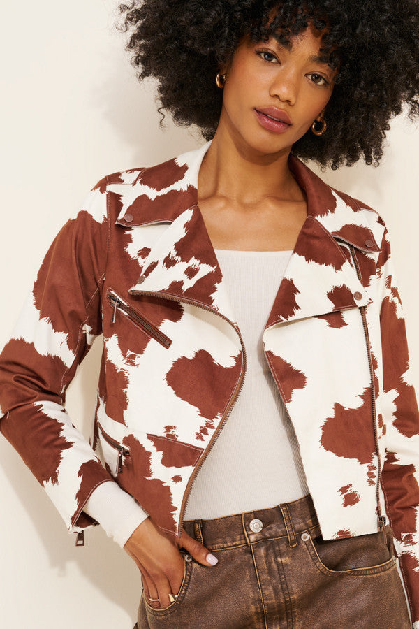 Woman wearing a brown and white patterned jacket with a plain background
