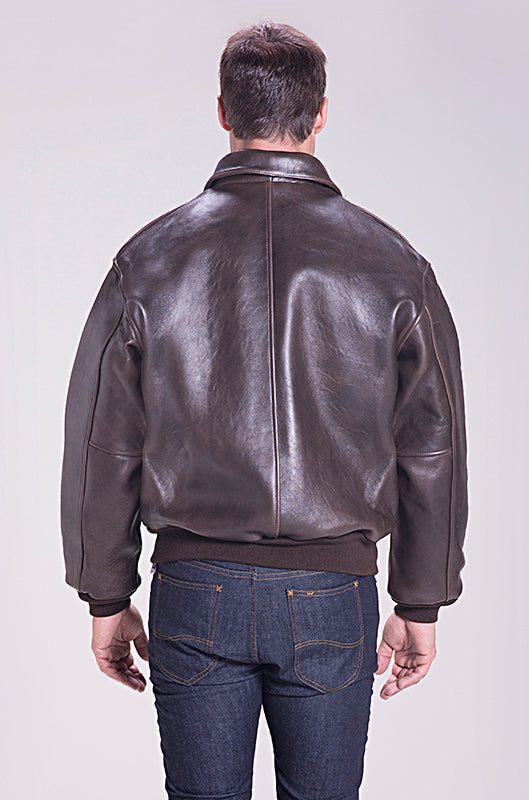 Man wearing a brown leather jacket and blue jeans on a white background