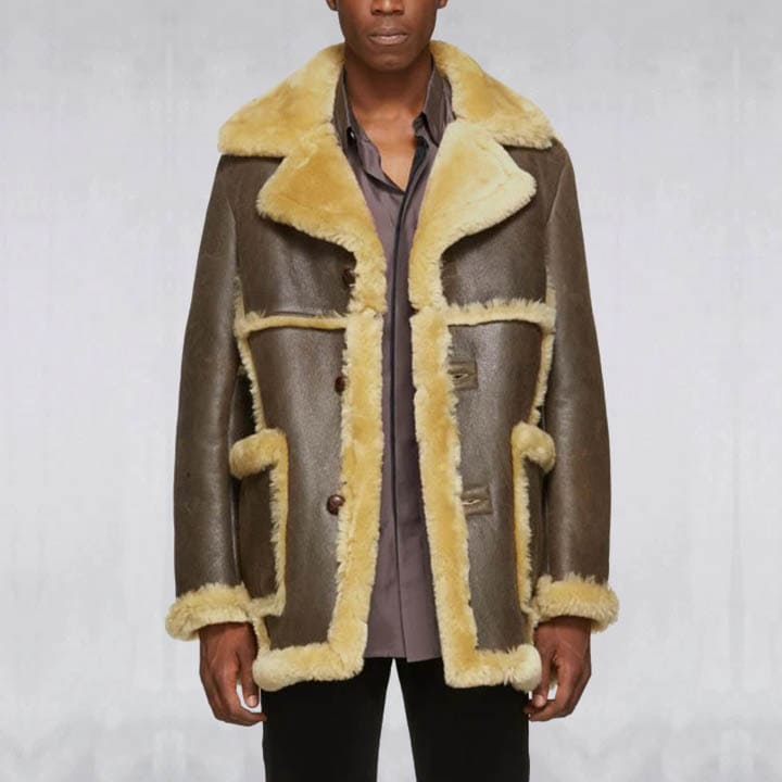 Man wearing a brown leather coat with yellow fur trim on a plain background
