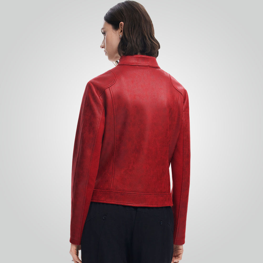 A woman shown from the back wearing a red faux-leather jacket and black trousers, photographed against a light gray studio background.