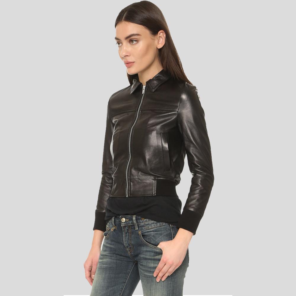 Woman wearing a black leather jacket and jeans on a gray background