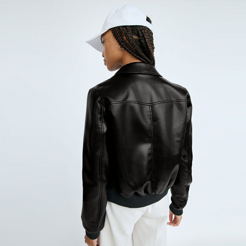 Person wearing a black leather jacket and white cap on a light gray background