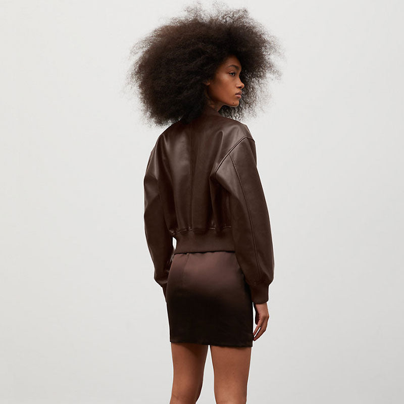 Person wearing a brown leather outfit on a plain background