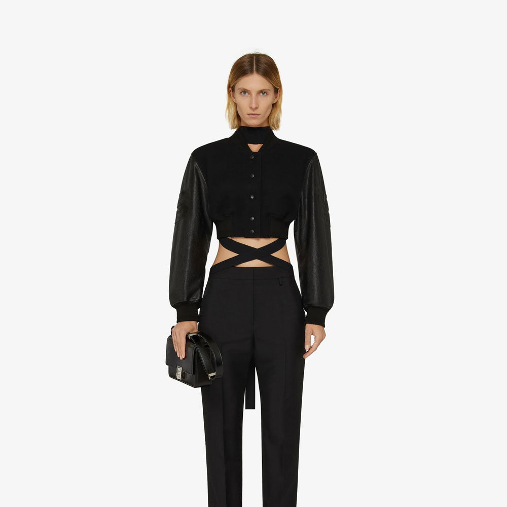 Woman wearing a black outfit with cut-out design on a white background