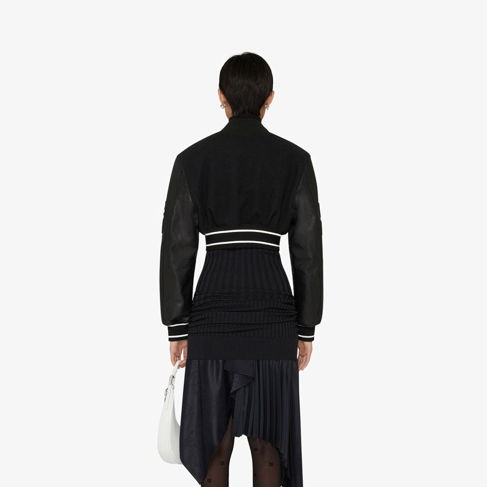 Person wearing a black outfit with white accents on a white background