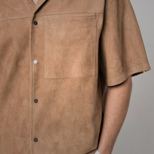 Close-up of brown goatskin suede shirt with chest pocket and button closure