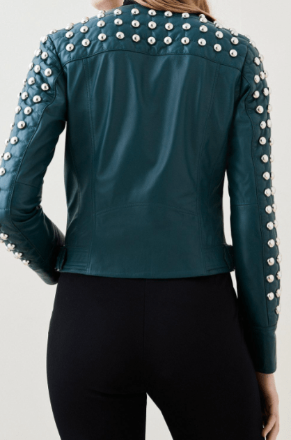 A teal green leather jacket with silver studs on the shoulders and sleeves, shown from the back on a model wearing black pants.