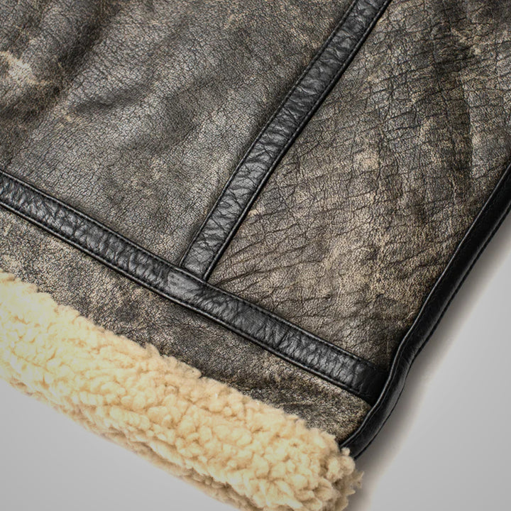 Close-up of a textured leather surface with a visible seam and a layer of beige sheepskin fur.