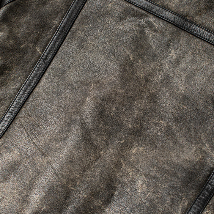 Close-up of a textured gray leather surface with a zipper.