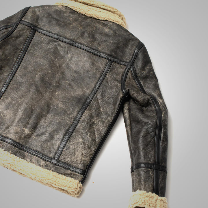 Brown leather jacket with beige shearling lining on a light gray background