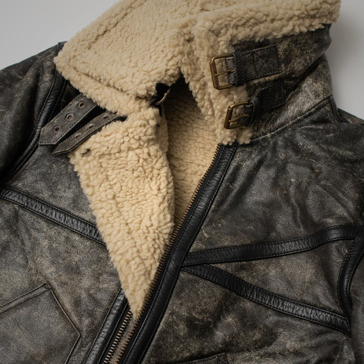 Close-up of a leather jacket with beige shearling lining on a neutral background