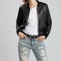 Person wearing a black leather jacket, white shirt, and ripped jeans on a light gray background
