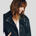 Woman wearing a black leather jacket on a plain background