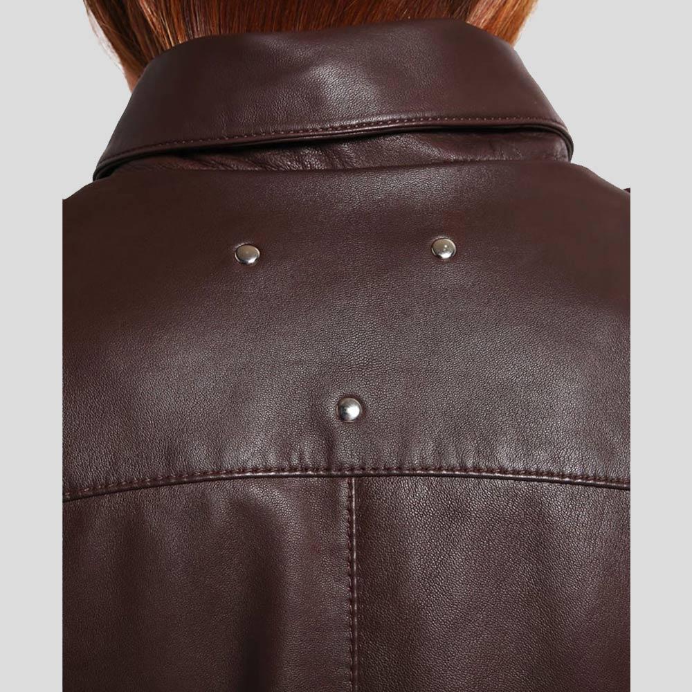 Close-up of a brown leather jacket with buttons on a light gray background