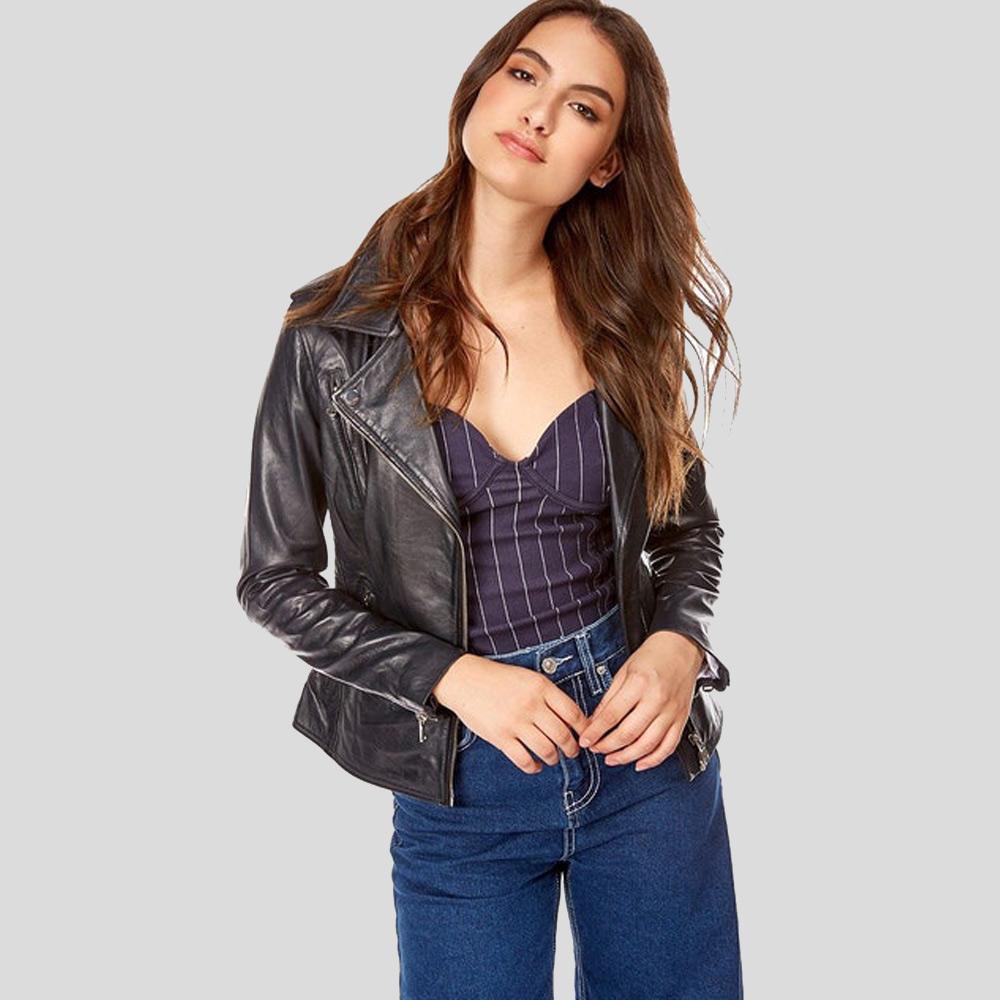 Woman wearing a black leather jacket, purple top, and blue jeans on a gray background