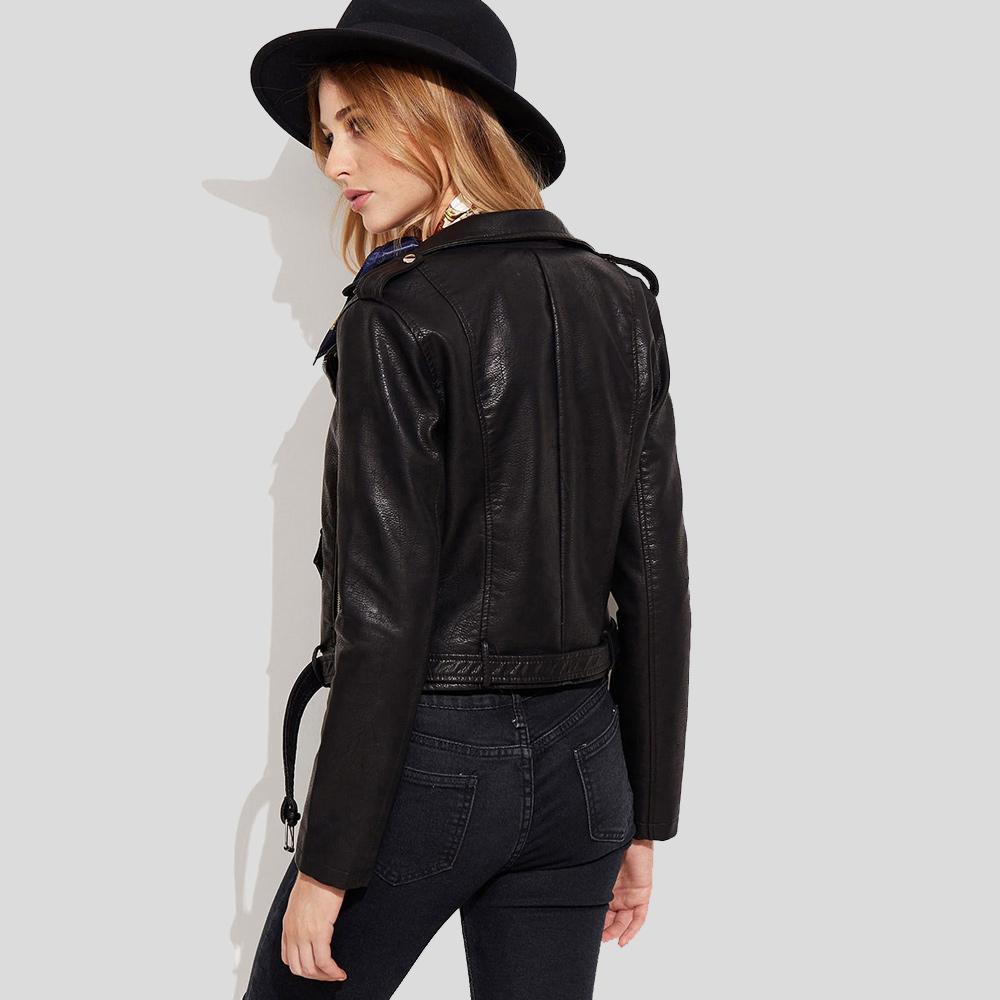 Woman wearing a black leather jacket and hat against a light gray background