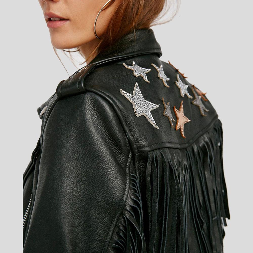 Black leather jacket with star embellishments and fringe details on a plain background