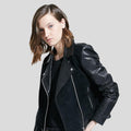 Person wearing a black leather jacket on a light gray background