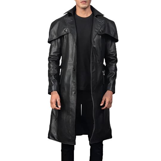 A man wearing a long black leather trench coat over a black shirt and black pants, shown against a plain white background.