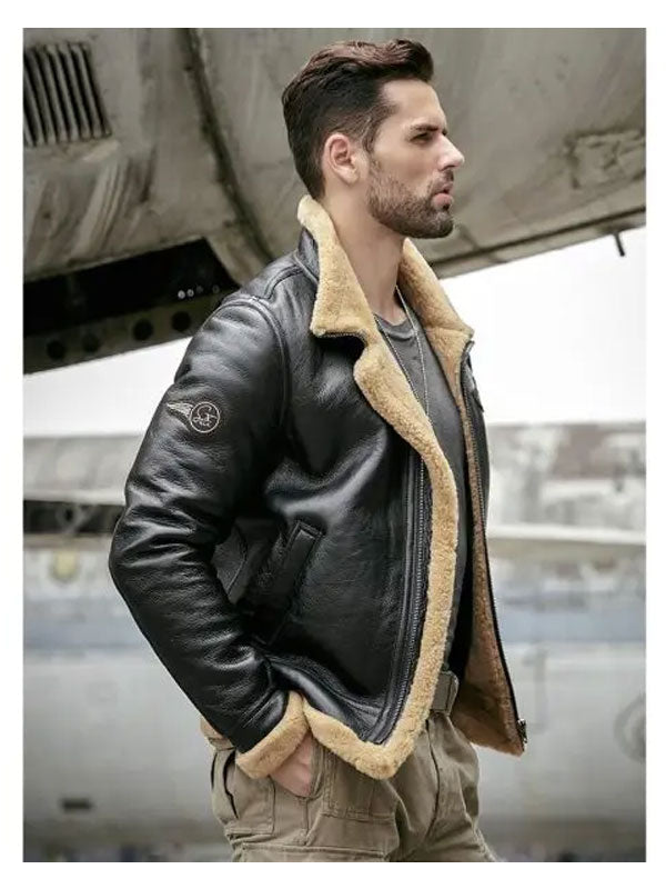 Man wearing a black leather jacket with beige fur lining, standing in front of an airplane.
