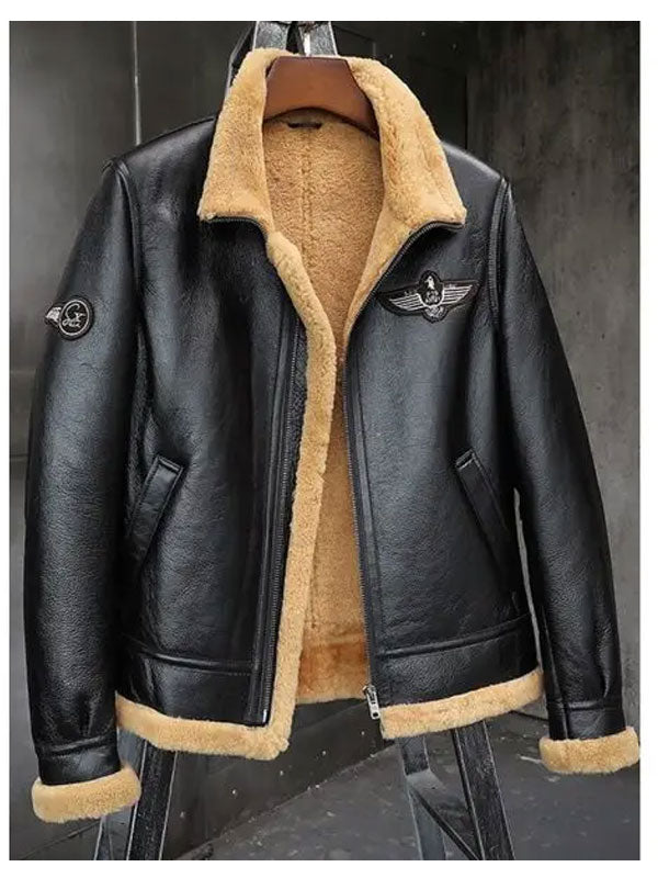 Black leather jacket with beige fur lining on a hanger against a dark background