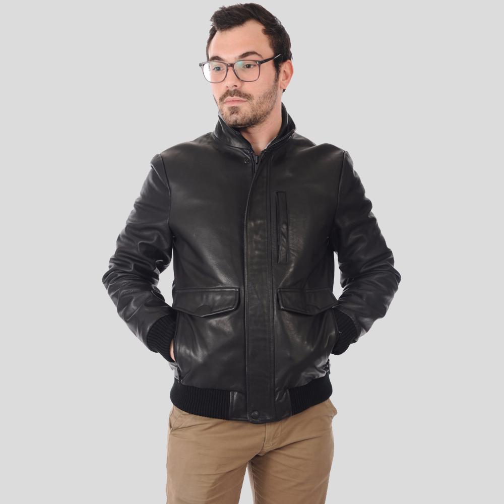 Man wearing a black leather jacket on a gray background