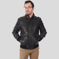 Man wearing a black leather jacket on a gray background