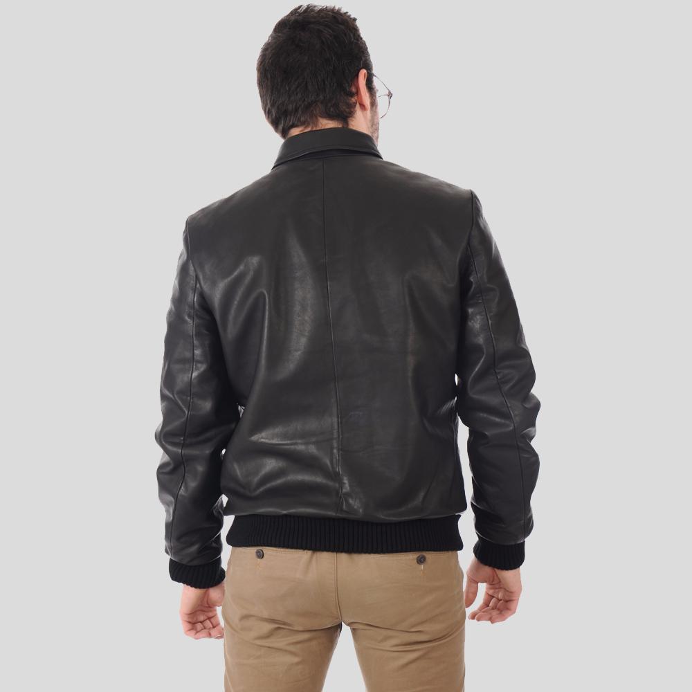 Man wearing a black leather jacket on a gray background