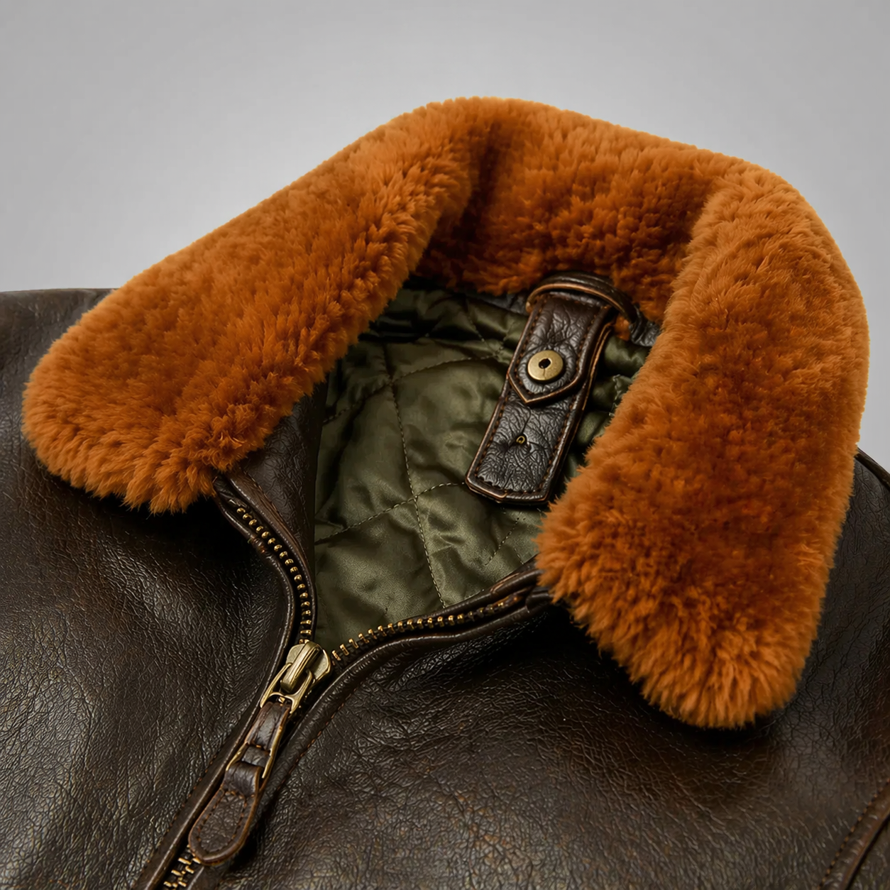 Close-up of a leather jacket with a fur-lined collar on a gray background