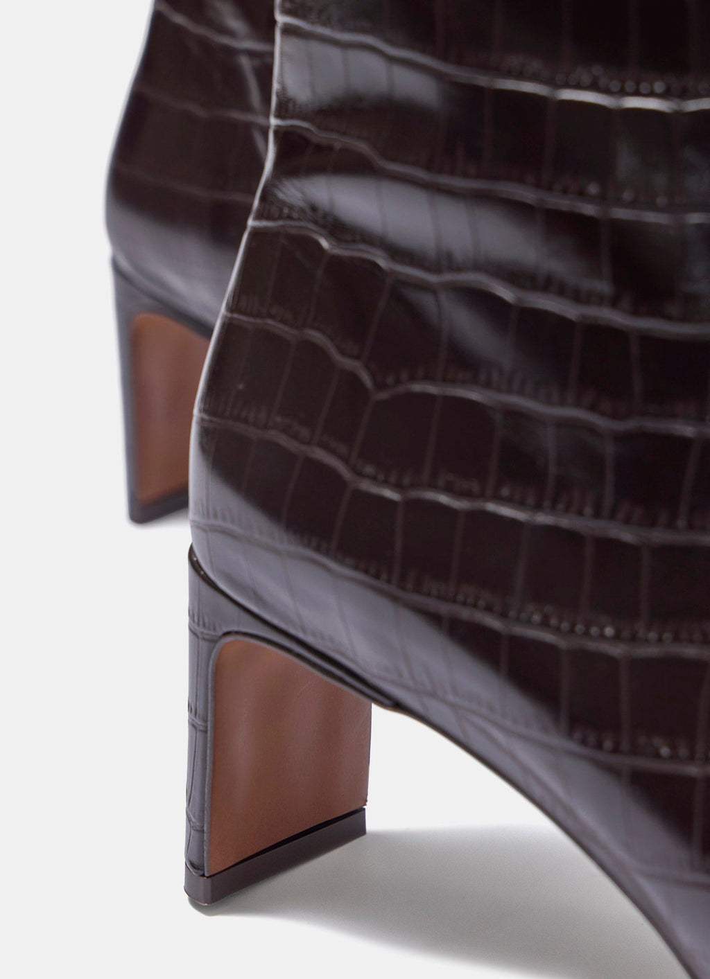 Close-up of a brown crocodile-patterned high-heeled shoe on a white background
