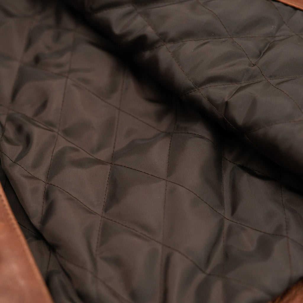 Close-up of quilted brown fabric with diamond pattern