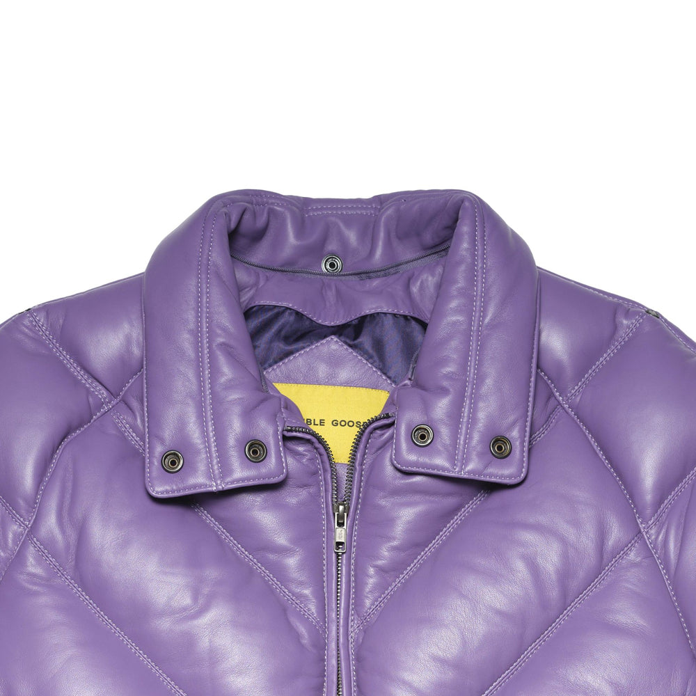 Close-up of a purple quilted puffer jacket with a collar, snap-button tabs, and a yellow inner label reading 'DouBLE GOOSE'.