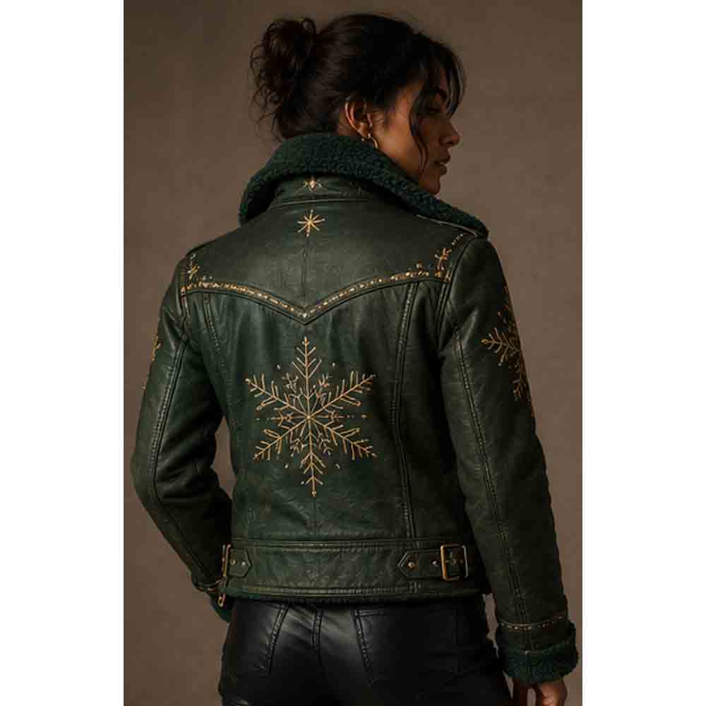 A woman shown from the back wearing a dark green leather jacket with a dark green sherpa collar and gold embroidered snowflake designs on the back.