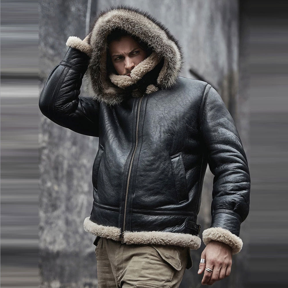 Person wearing a black leather jacket with fur trim against a gray background