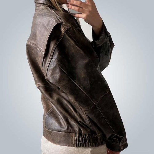 Brown leather jacket worn by a person on a plain background