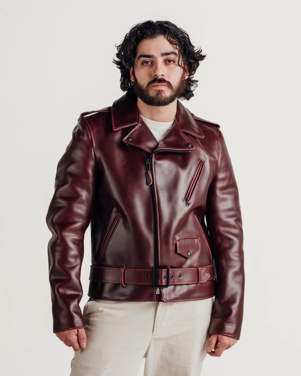 Man wearing a leather jacket on a plain background