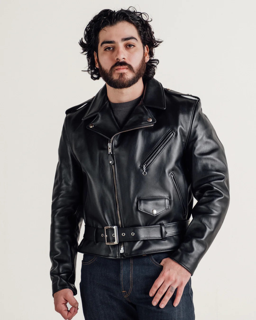 Man wearing a black leather jacket on a plain background